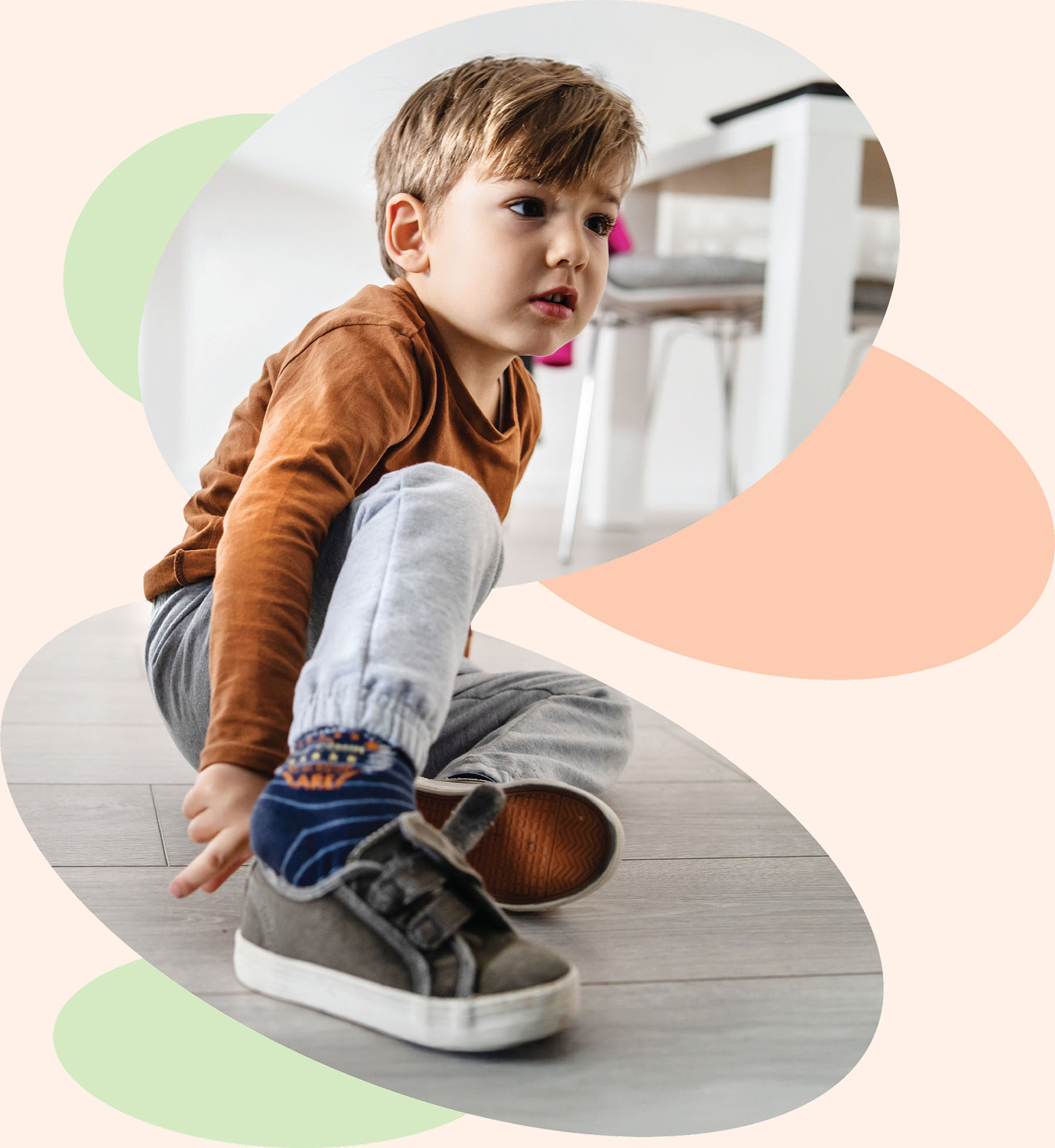 Young child practicing self care and motor planning skills while putting on shoes with pediatric occupational therapy support